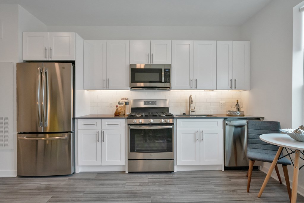a kitchen with stainless steel appliances and white cabinets