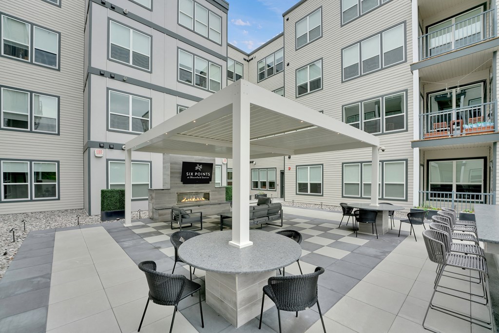 an outdoor patio area with a fireplace and tables and chairs