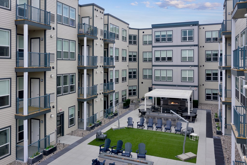 an exterior view of an apartment building with a lawn and a amphitheater