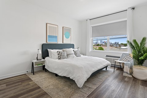 A bedroom with a large bed and a view of the city.