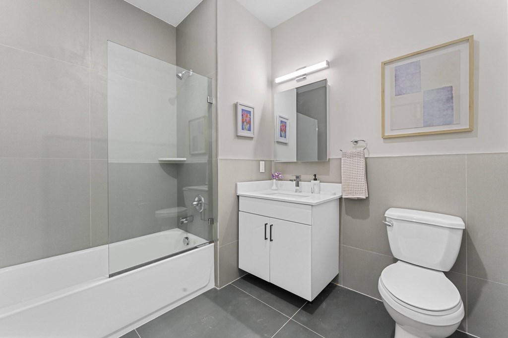 A white bathroom with a toilet, sink, and shower.