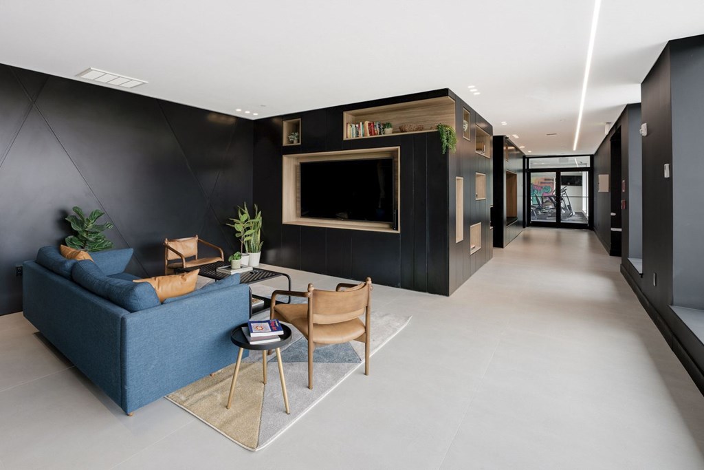 A living room with a blue sofa, a chair, a small table, and a television.