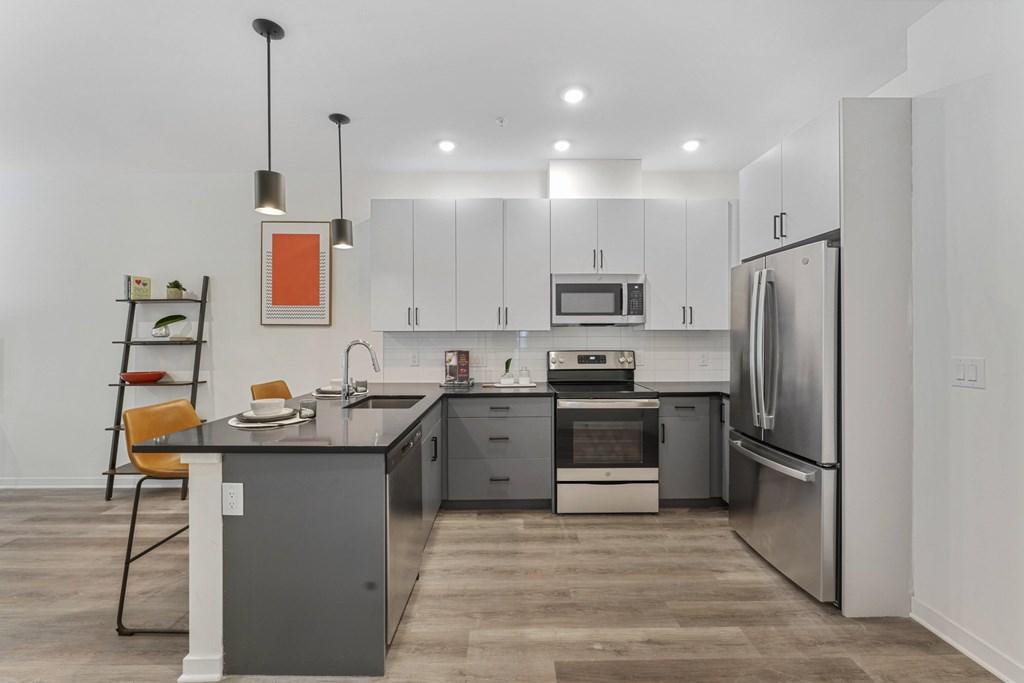 A modern kitchen with a wooden floor and stainless steel appliances.