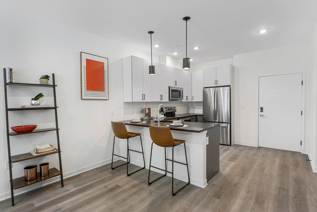 A modern kitchen with a white countertop and a refrigerator.