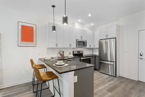 A kitchen with a table and chairs and a fridge.