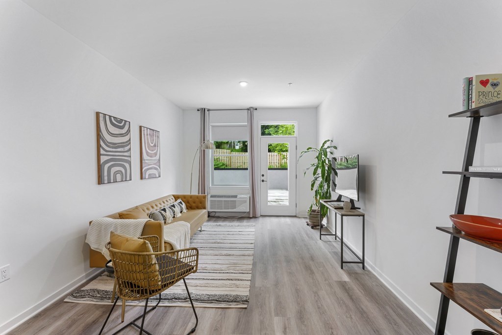A living room with a sofa, chair, and a painting on the wall.