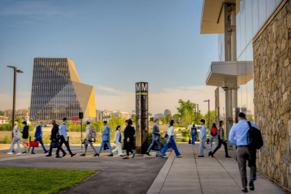 People walking on a sidewalk in front of a building.