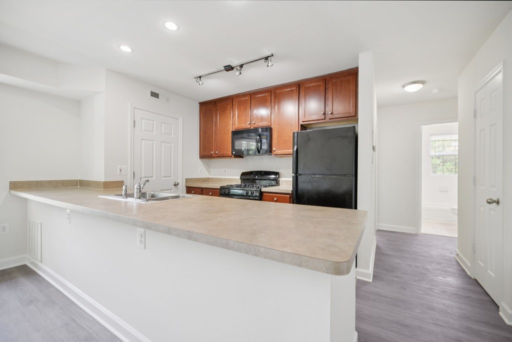 A kitchen with a white counter and brown cabinets.
