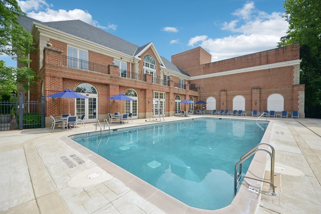 A large swimming pool in front of a brick building.