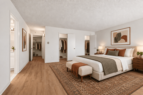 A bedroom with a large bed and a bench in front of it.