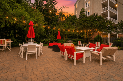 A patio with tables and chairs is set up for an evening outside.