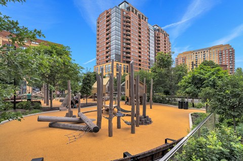 a playground in a city park with tall buildings