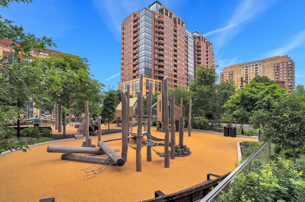 a playground at a park with tall buildings