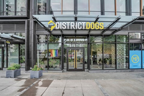 the front of a building with a sign that reads district dogs