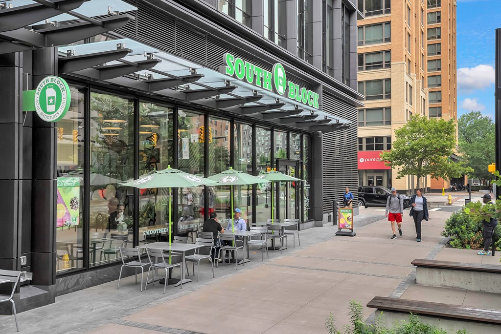 people walking down a sidewalk in front of a coffee shop