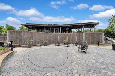 a circular patio with tables and chairs in front of a building