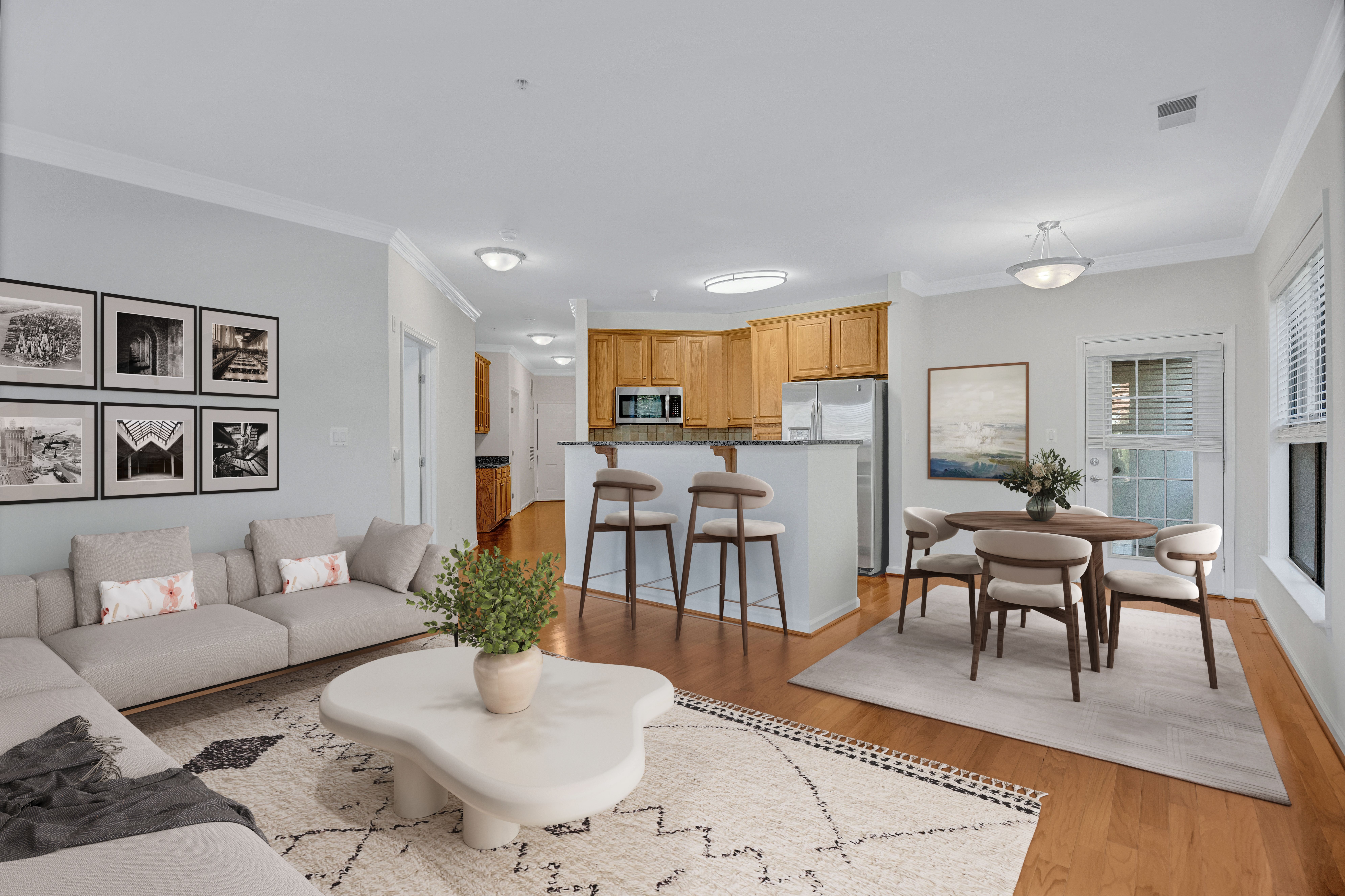 A modern living room with a grey sofa, a coffee table, and a dining table set up.