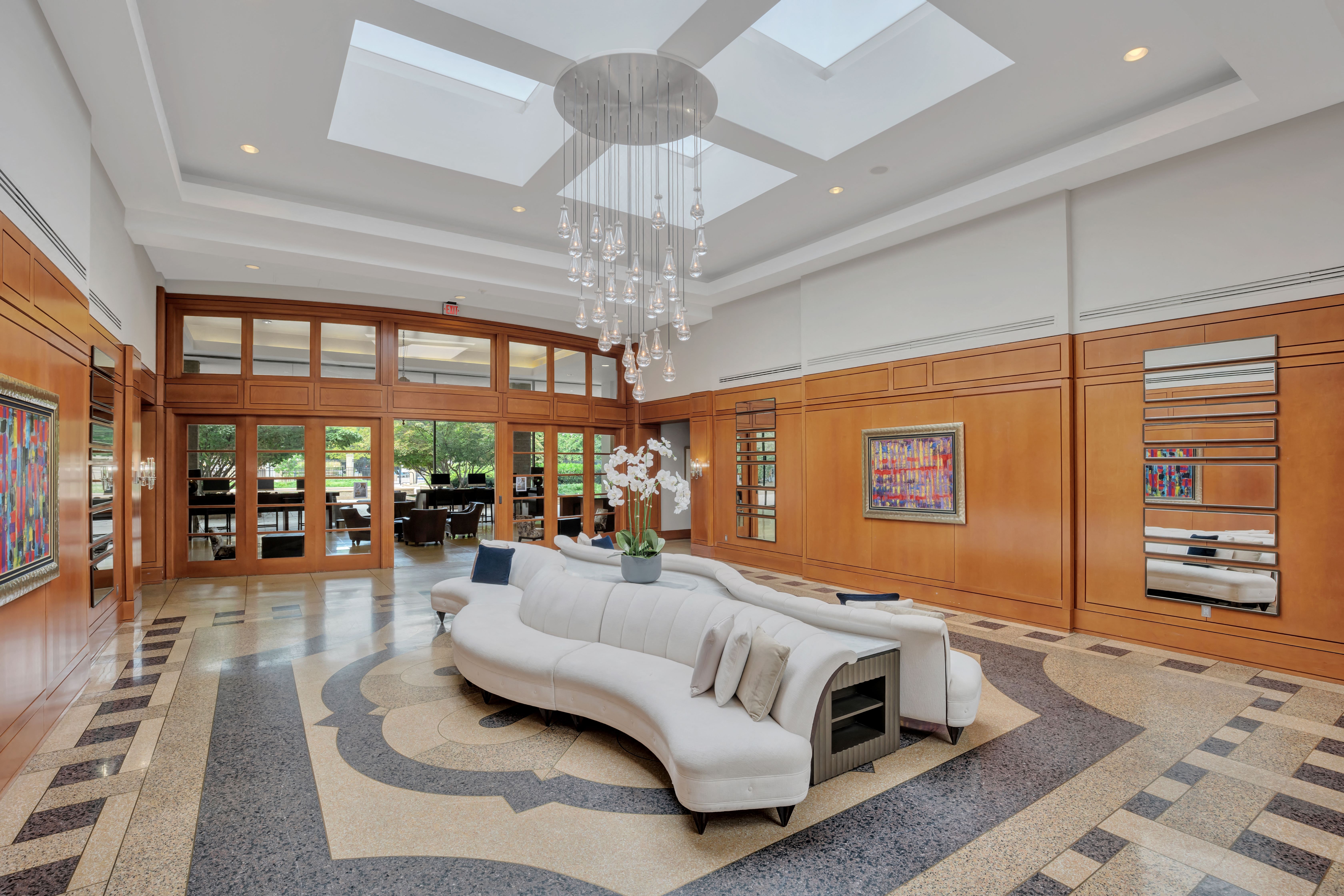 a large living room with a white couch and a chandelier