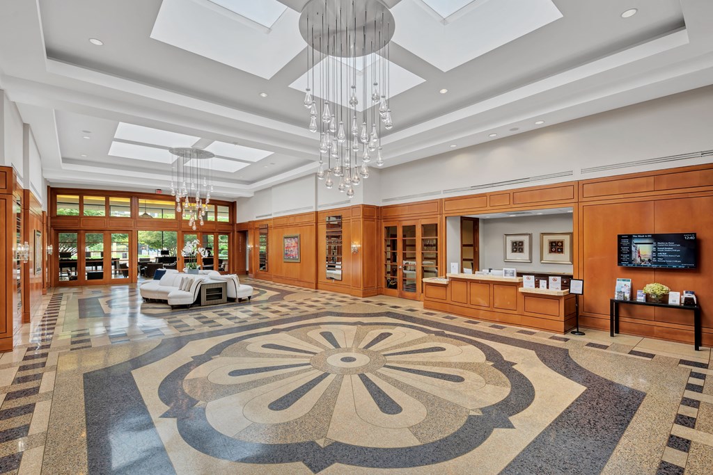 the lobby of a hotel with a rug and chandeliers