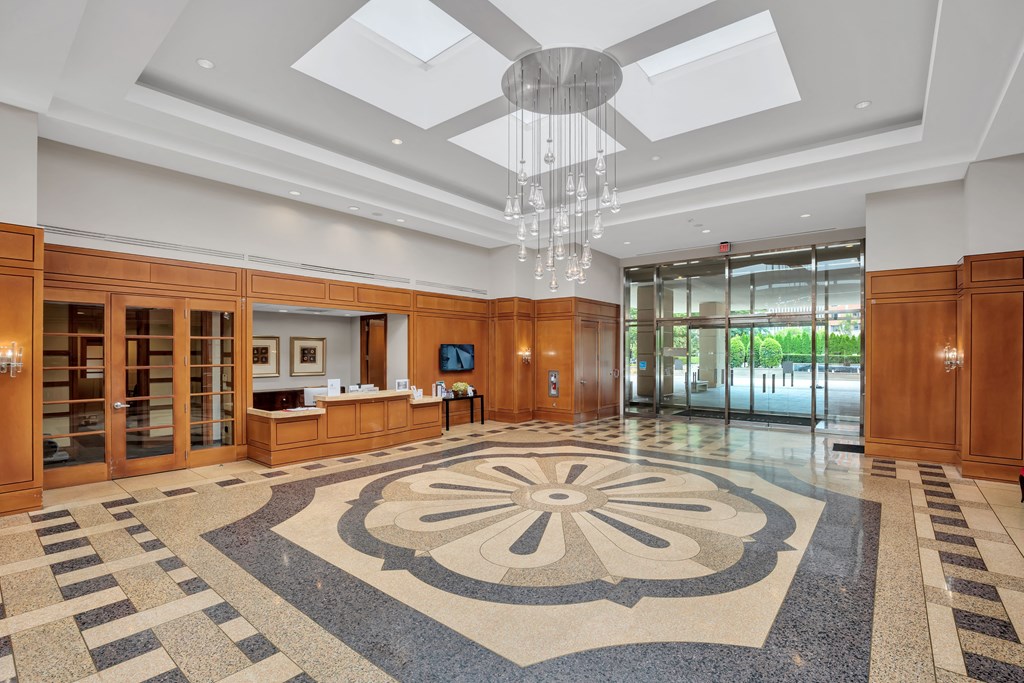 a large lobby with a geometric rug and a ceiling fan