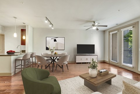 A living room with a green armchair, a wooden coffee table, and a television.