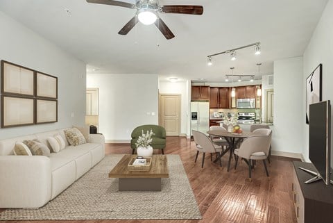 A living room with a white couch, a coffee table, and a ceiling fan.