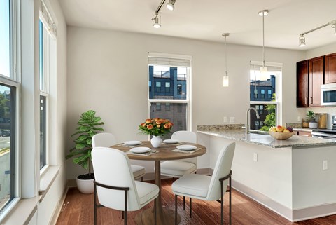 A kitchen with a table and chairs by a window.