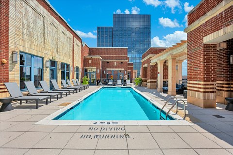 A pool surrounded by brick buildings with a sign that says