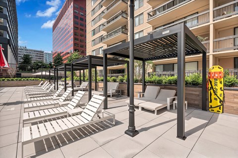 A sunny day at the rooftop pool with lounge chairs and umbrellas.