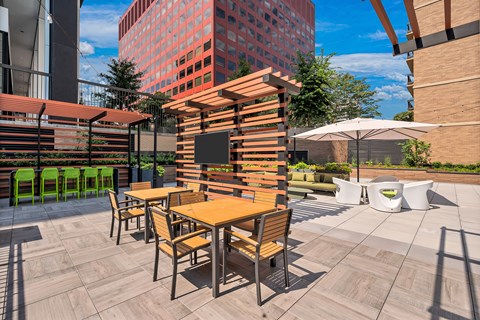 A wooden table and chairs are set up on a rooftop patio.