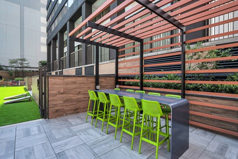 A patio with a table and chairs under a pergola.