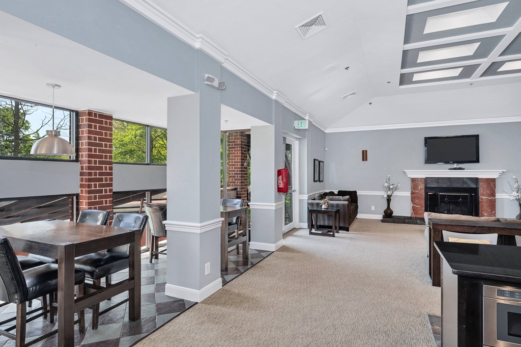 a common area with tables and chairs and a fireplace