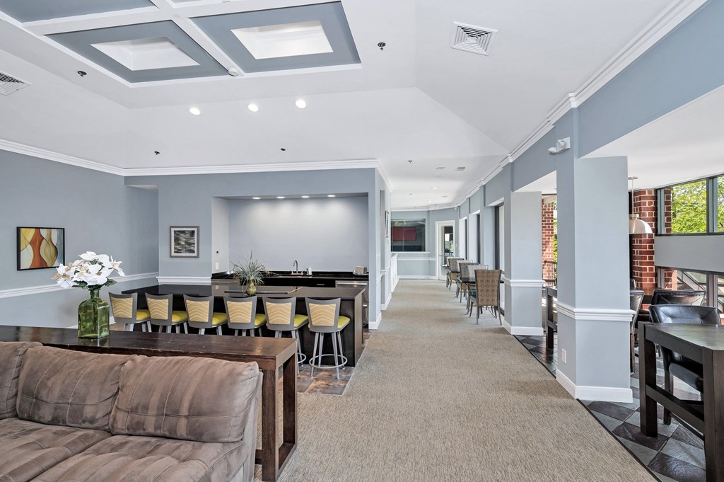 a room with a couch and chairs and a projector screen on the wall