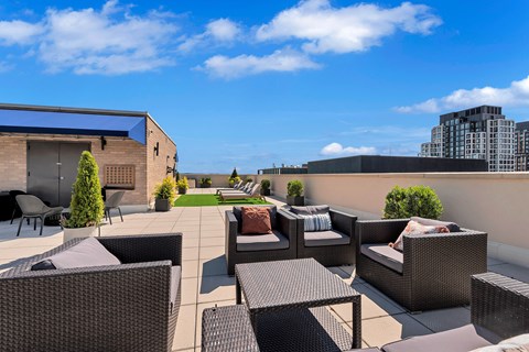 A patio with black furniture and a blue sky.