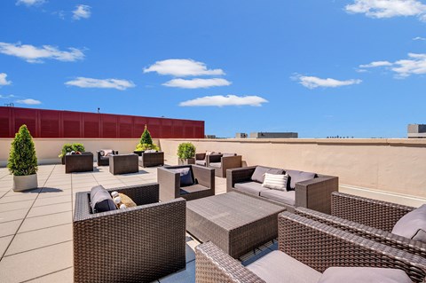 A patio with brown furniture and a red wall.