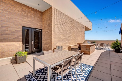 A patio with a table and chairs is surrounded by a brick wall.
