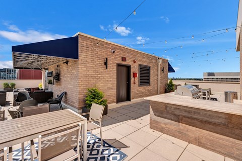 A patio with a table and chairs is surrounded by a brick building.