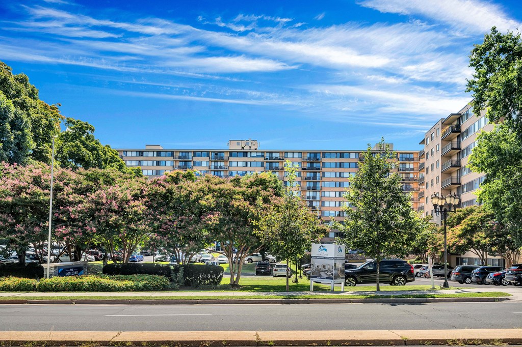 a large building with many windows and trees in front of it