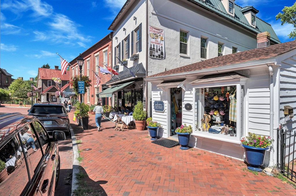 a city street with shops and a car on it