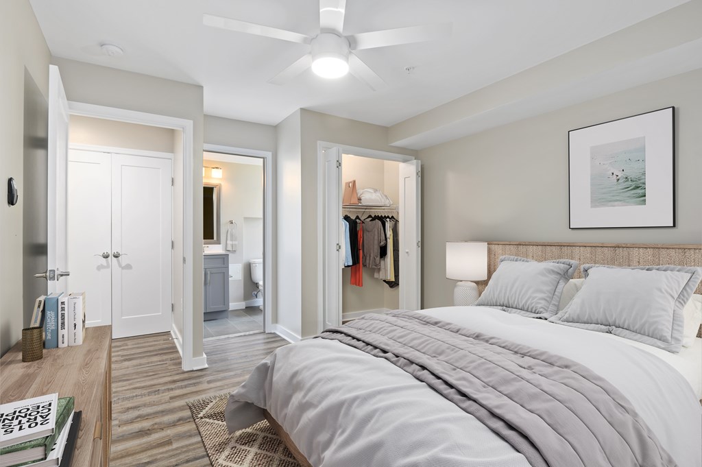 A bedroom with a large bed and a ceiling fan.