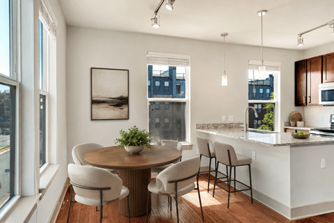 A modern kitchen with a dining table and chairs.