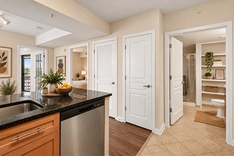 A kitchen with a black countertop and white cabinets.