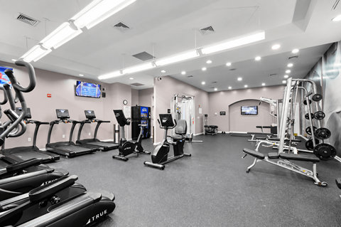A gym with treadmills, elliptical machines, and other exercise equipment.