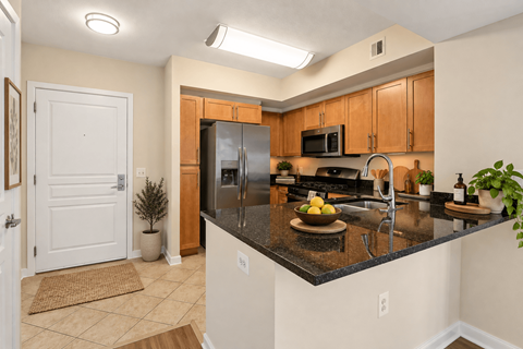 A kitchen with a black countertop and wooden cabinets.