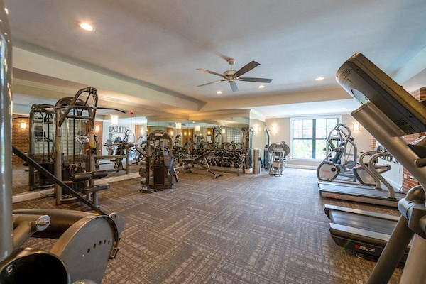a large fitness room with exercise equipment and a large window