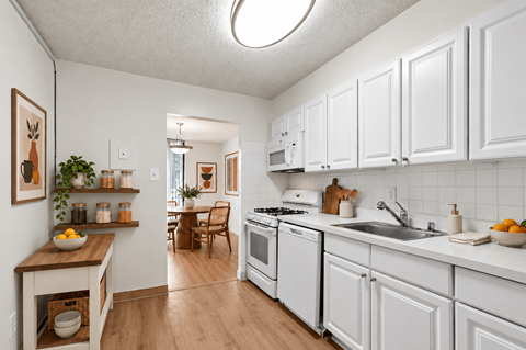 A kitchen with white cabinets and a wooden island.