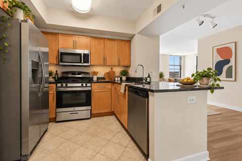 A kitchen with a refrigerator, oven, and microwave.