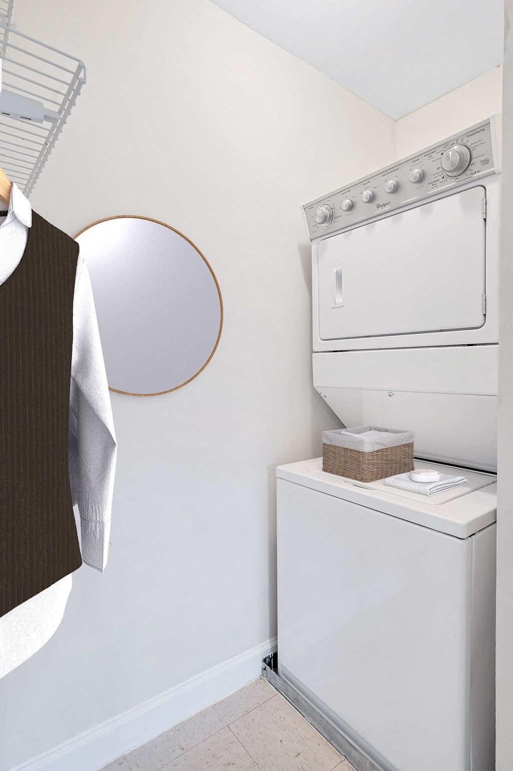 a white washer and dryer in a laundry room with a round mirror on the wall