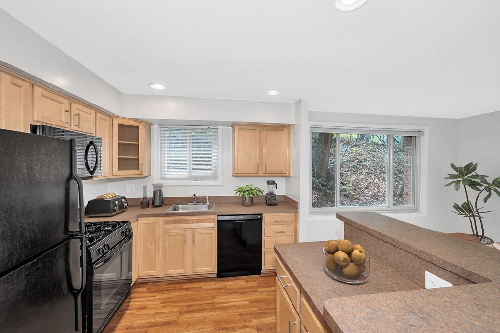 a kitchen with wooden cabinets and black appliances