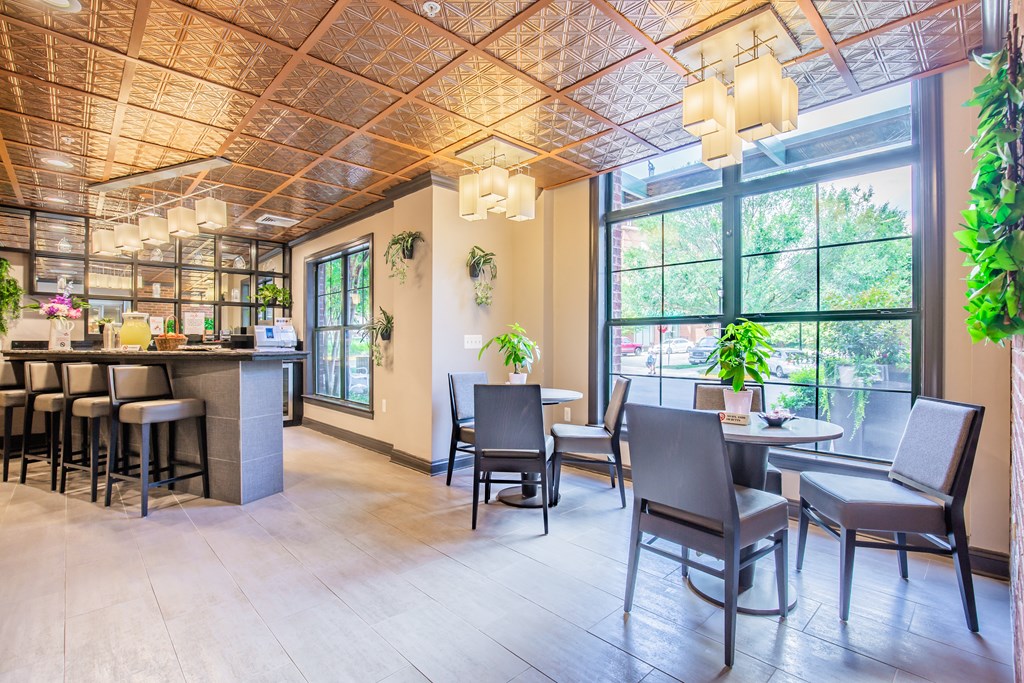 a room with a large window and tables with chairs